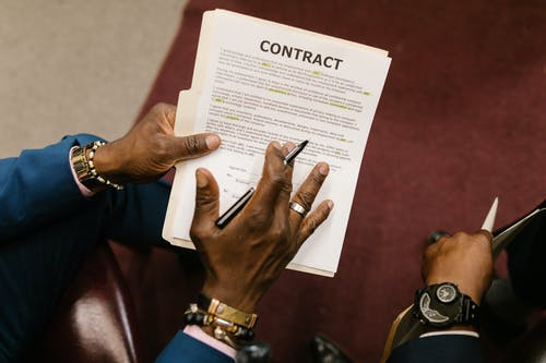 a man holding a pen and a contract to sign